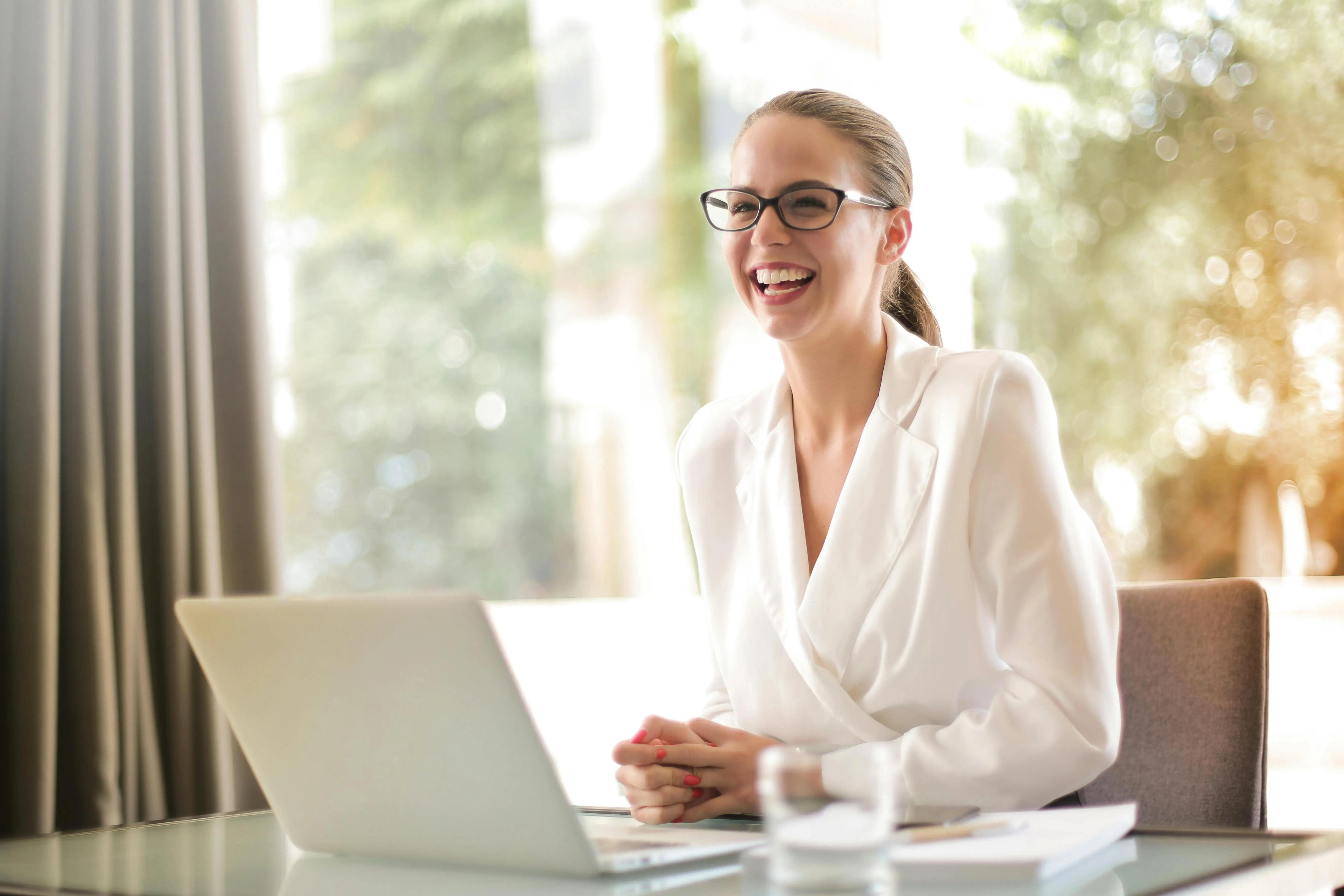 Professional woman smiling while working on laptop