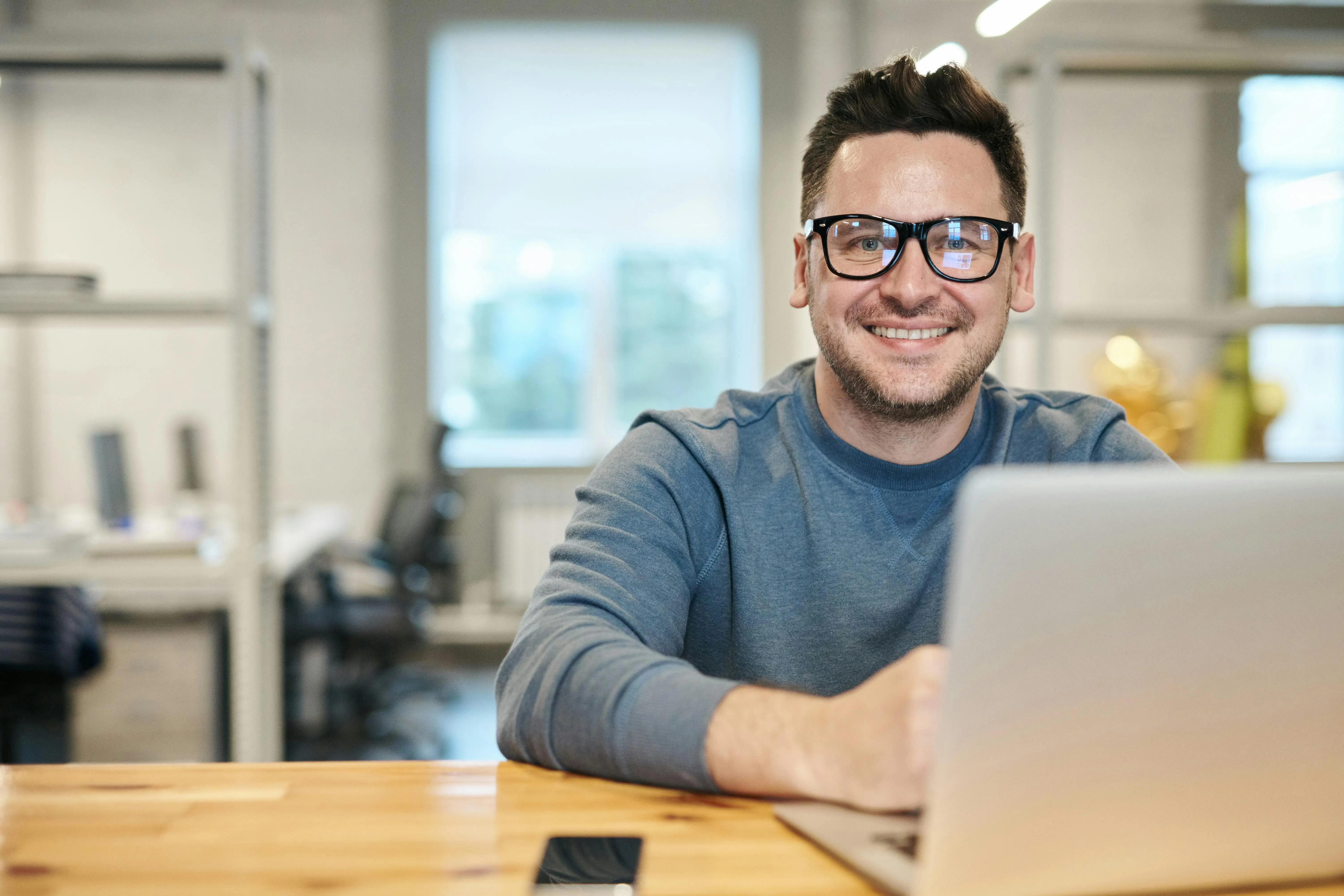 Professional man smiling while working on laptop